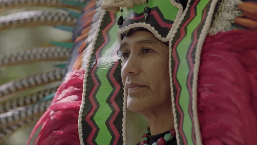 A person is wearing an elaborate native headdress