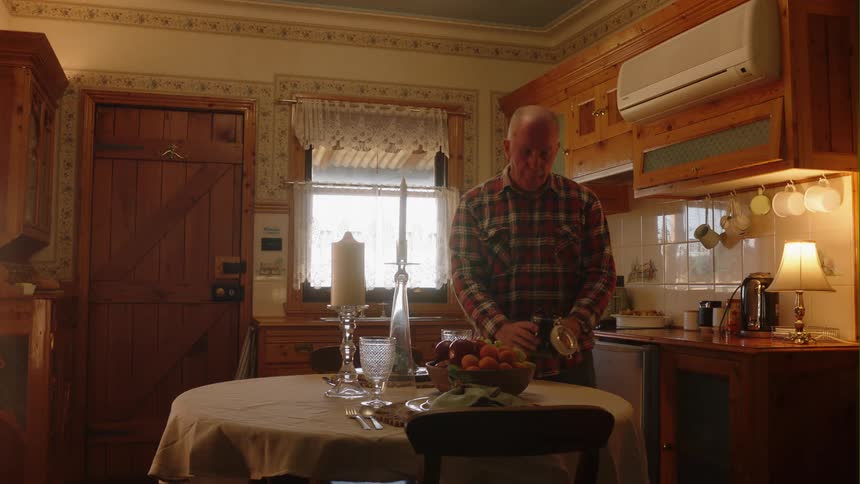 A man sets the table at home