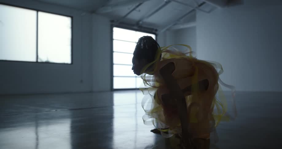 Female dancer performs routine in empty room with glossy floors