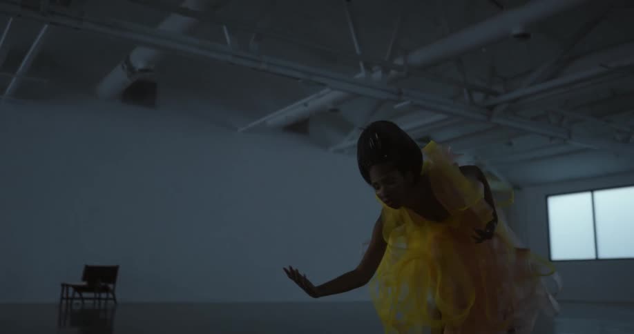 A woman performs a modern dance in a large open dance studio