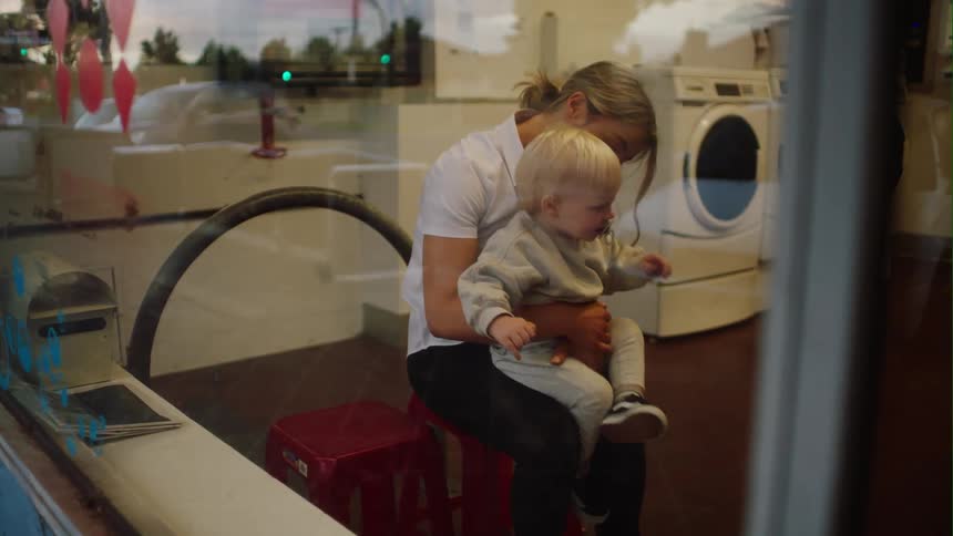 A woman holds and rocks her son in her lap