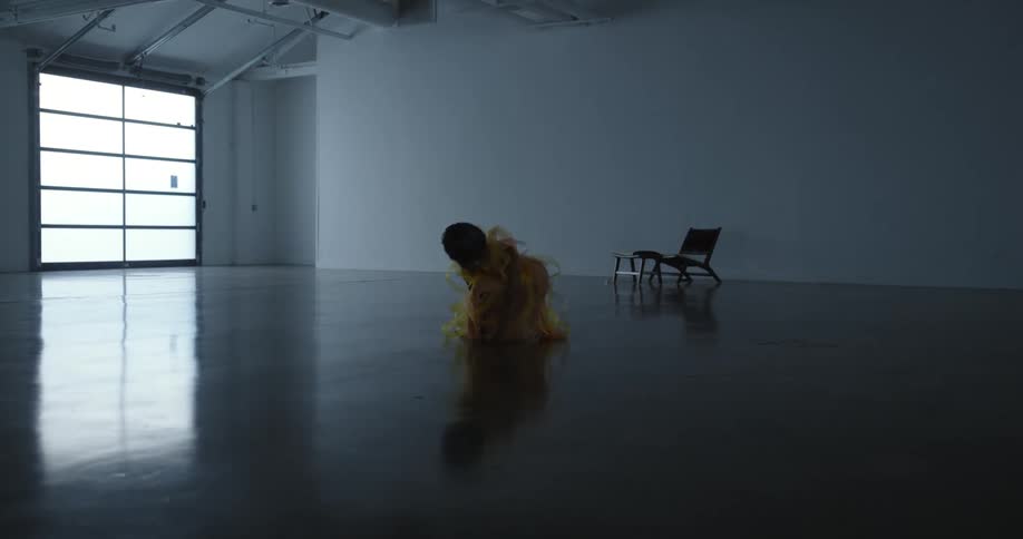 A woman falls to her knees as she dances