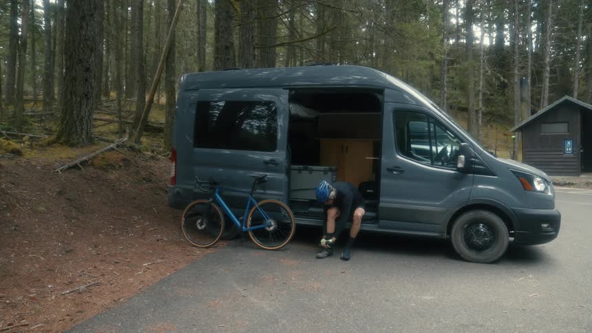 An elderly cyclist prepares to ride his bike in his Sprinter van