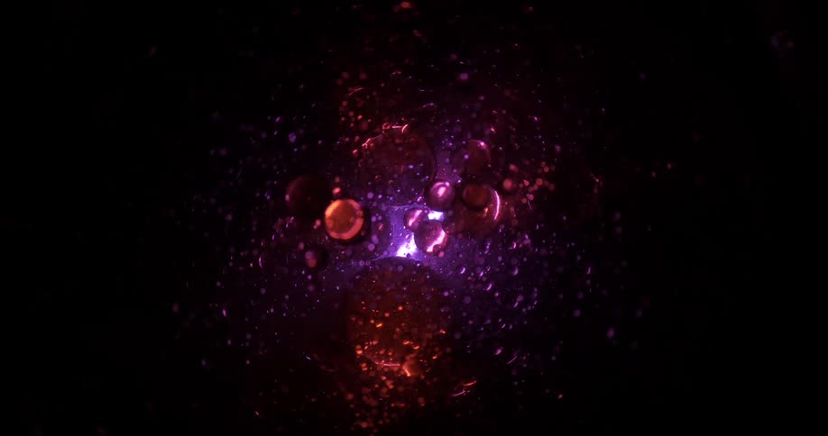 Purple and pink spheres float in the darkness as purple light shines from the vortex in the distance