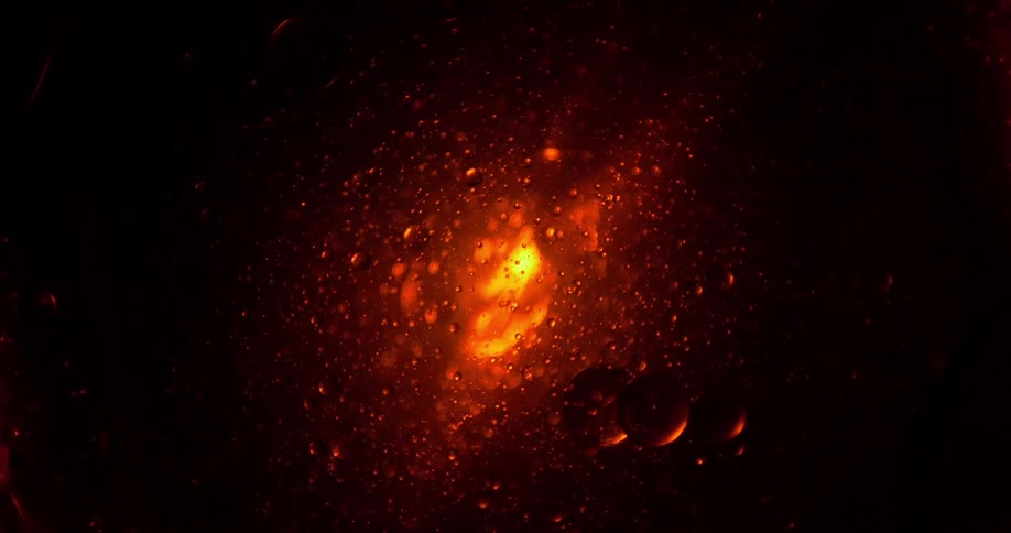 Droplets form in a liquid glowing orange and red