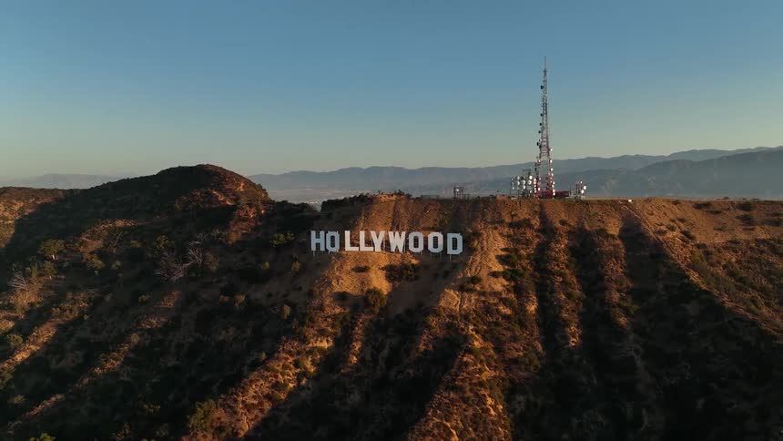 The hollywood sign on a hill with a tower up top