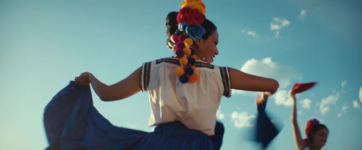 A group of folk dancers perform a dance in the desert