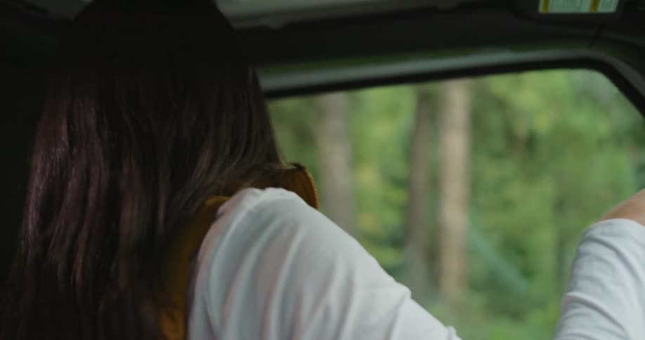 Woman gets into vehicle parked near woods and puts on seatbelt