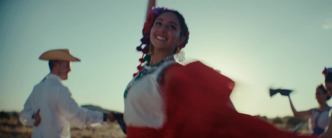 Group of dancers performing a traditional latin american folk dance outdoors at sunset