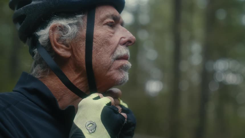 Male cyclist wears helmet in the woods