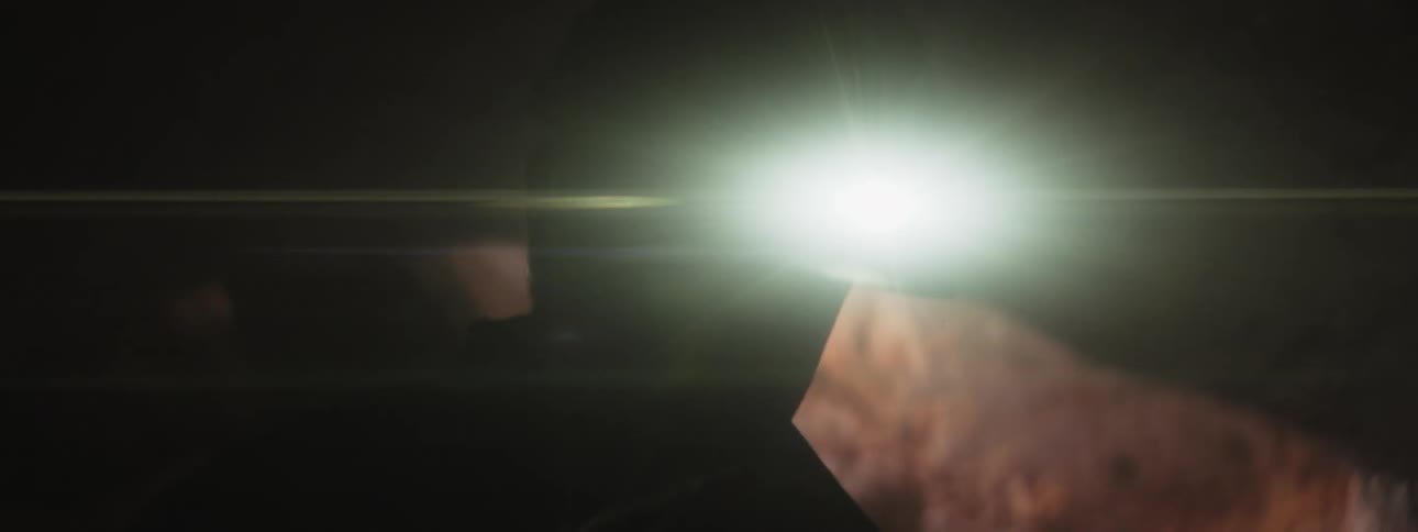 A man wears a headlamp while exploring a dark cave