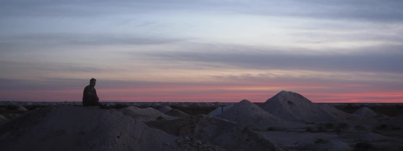 A man throws a rock on the hill
