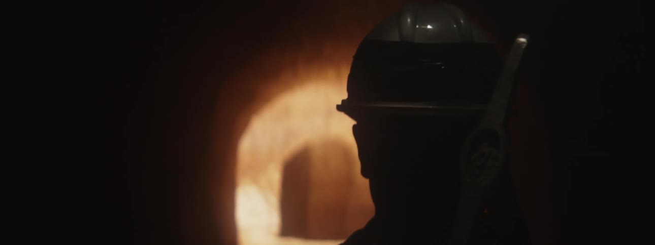 Miner walks through mine carrying a pickax