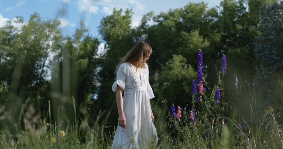 A woman poses in a field of wildflowers