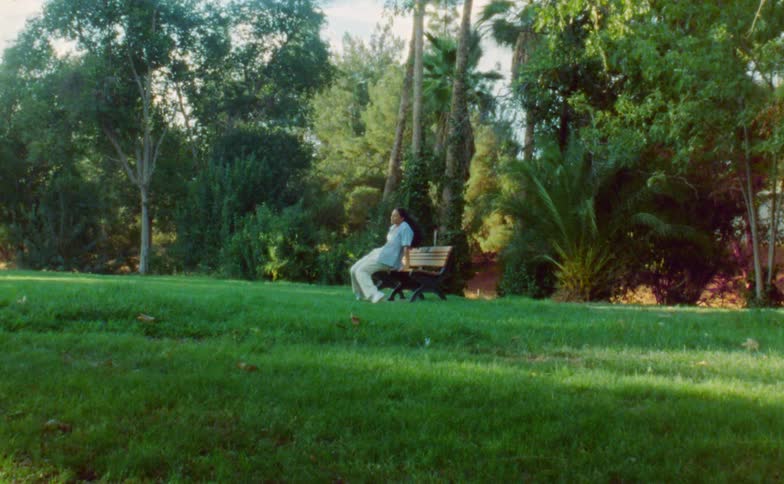 A woman performs a modern dance on a park bench