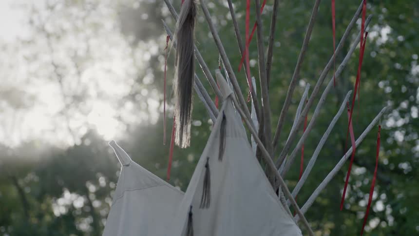 Tops of tribal structures with feathers hanging