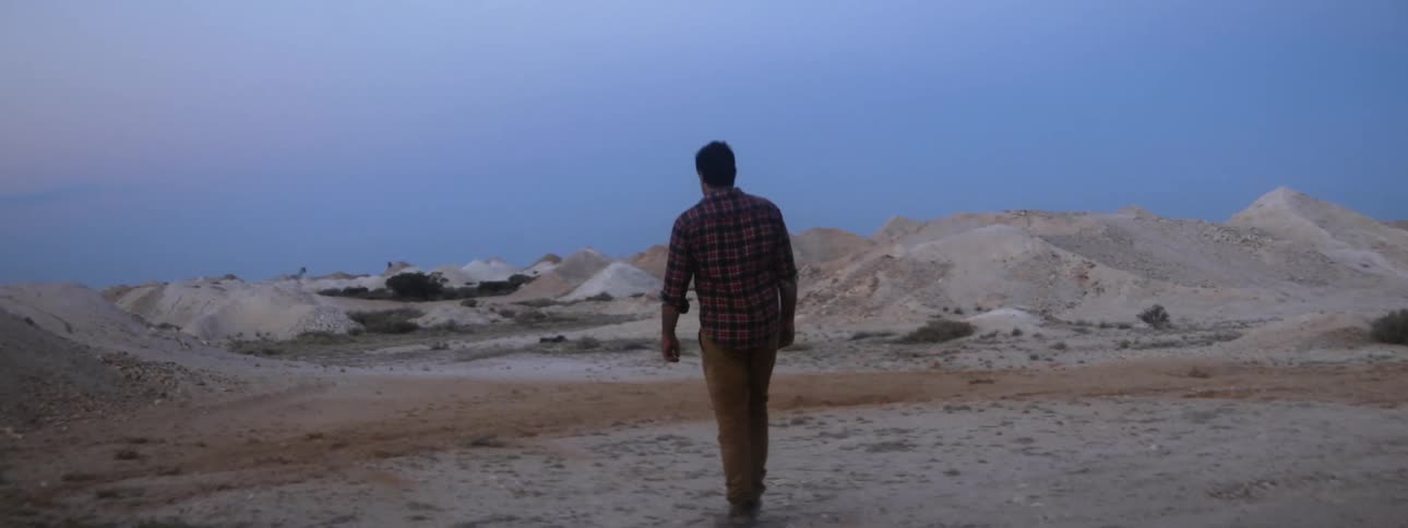 A man walks through a gravel pit at a construction site