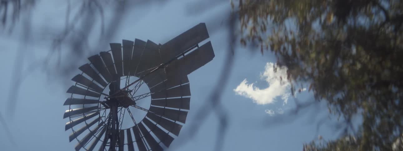 A view of a windmill on a farm