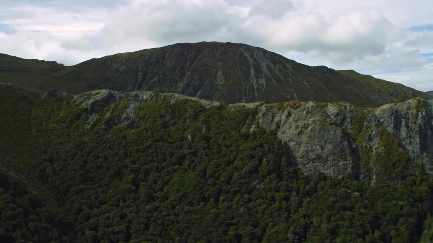An aerial tracking shot along a rocky ridgeline