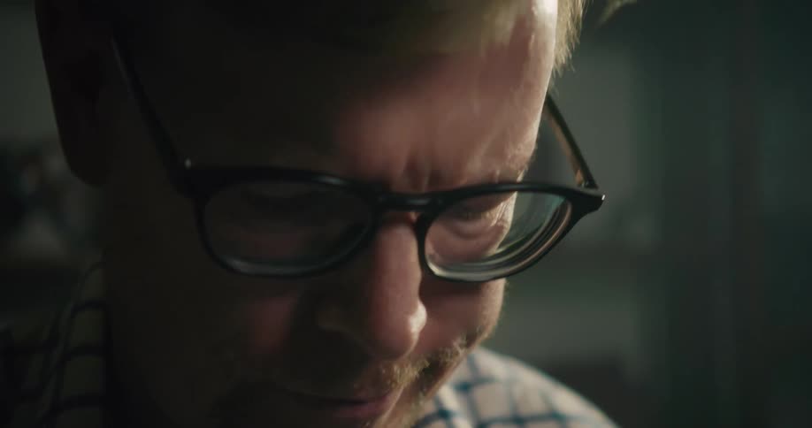 Redheaded man looks down while working