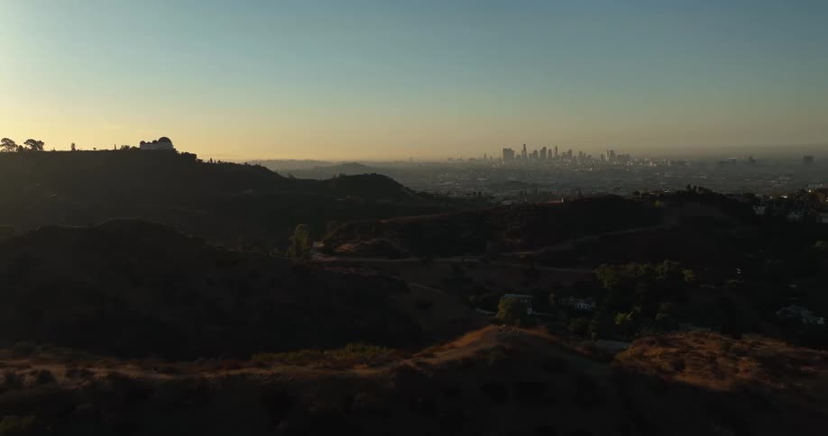 A city skyline is visible in the distance from a cliff in a canyon
