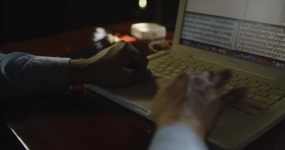 A man types on a laptop