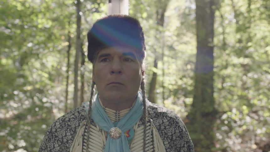 Tribal man walking through a forest