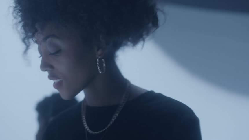 A woman dances in a club as lights flash
