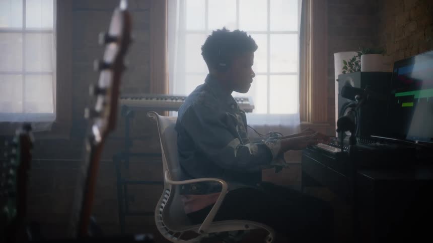 A young man records himself playing keyboard