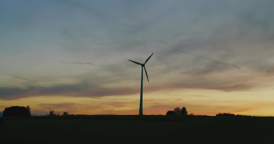 A wind turbine spins in a field