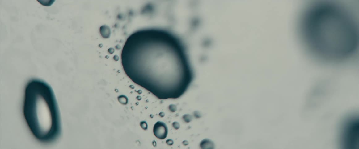 Light shines on droplets of moisture on a hard surface and then the environment becomes dark