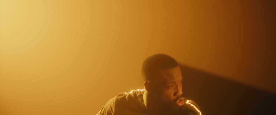 Flashes of light surround a man as he swims in and out of a wall
