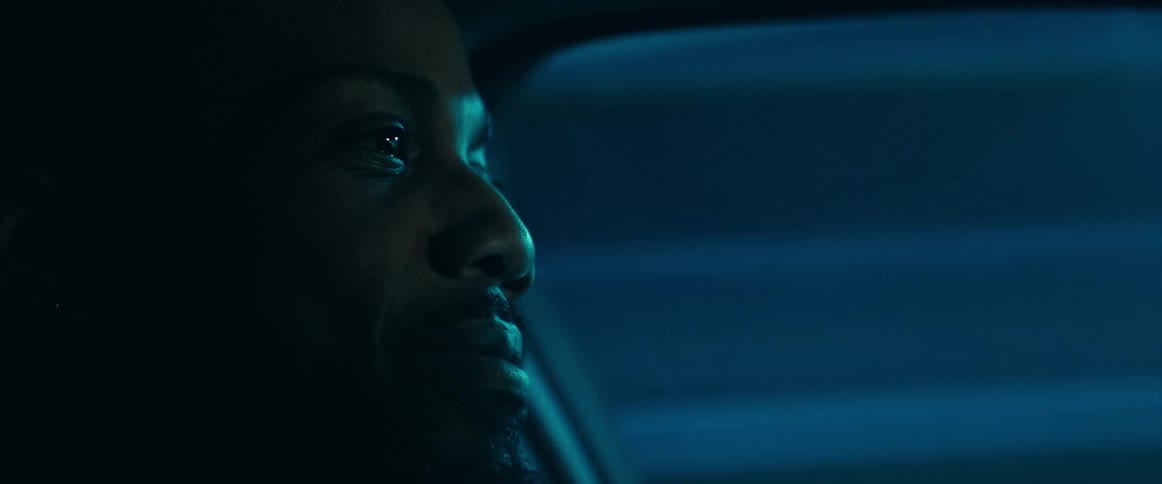 A man drives a car through a dim tunnel