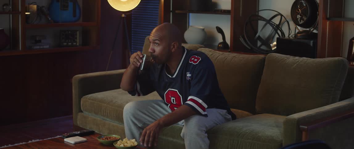 A man watching football while having snacks
