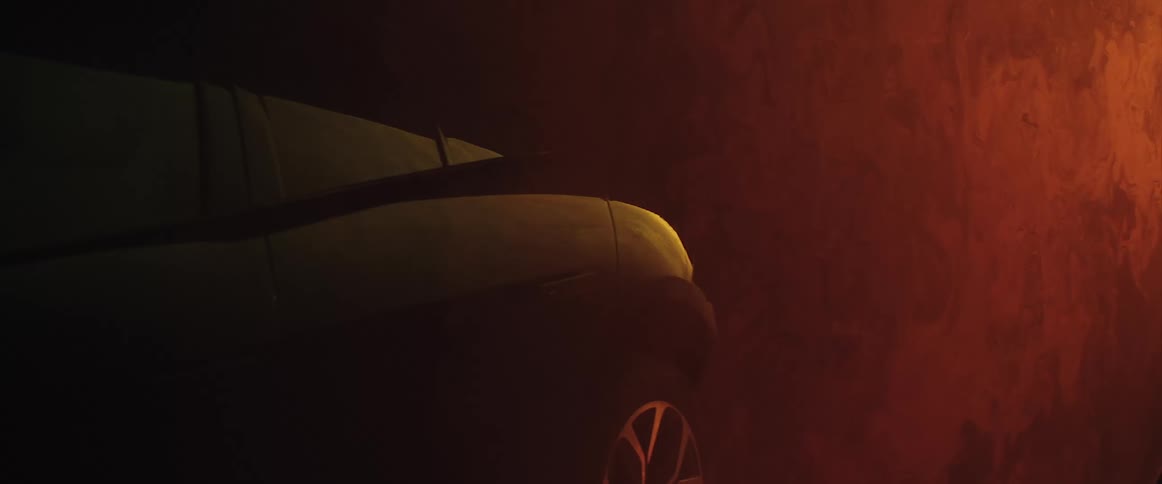 A strange red atmosphere moves and wavers as a yellow light moves across an automobile