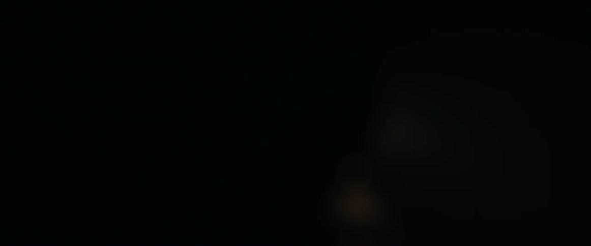 Rain is falling on the windshield at night