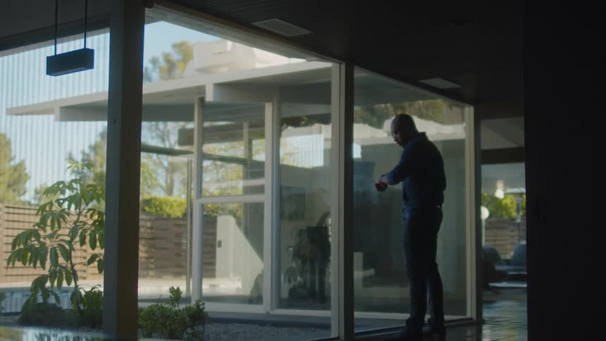 A man looking out the windows in a house