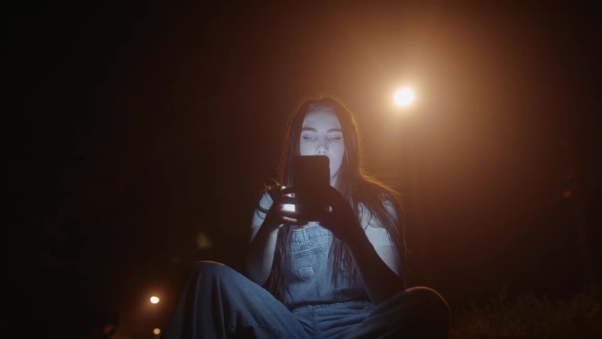 A woman texting while sitting outside
