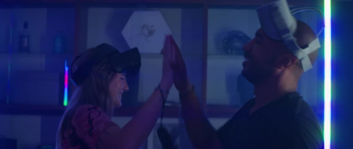 A man and woman high fiving after playing a virtual reality game