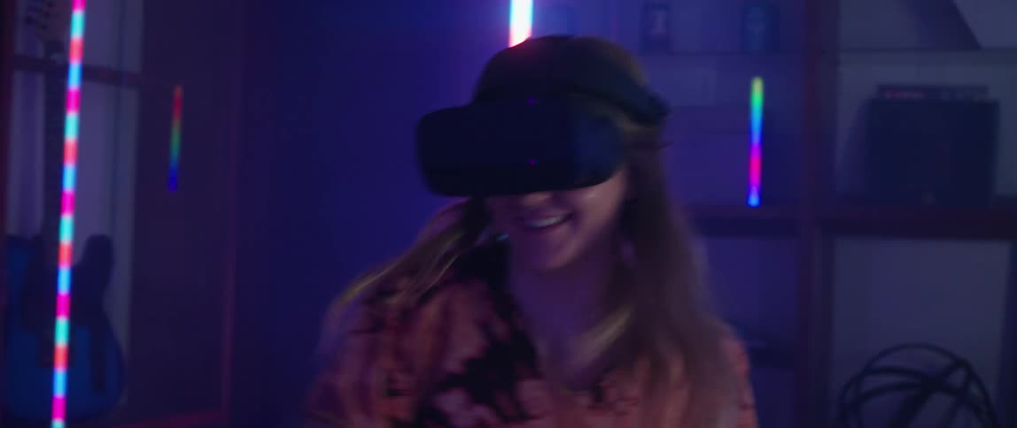 A man and woman swing their arms as they play a virtual reality game