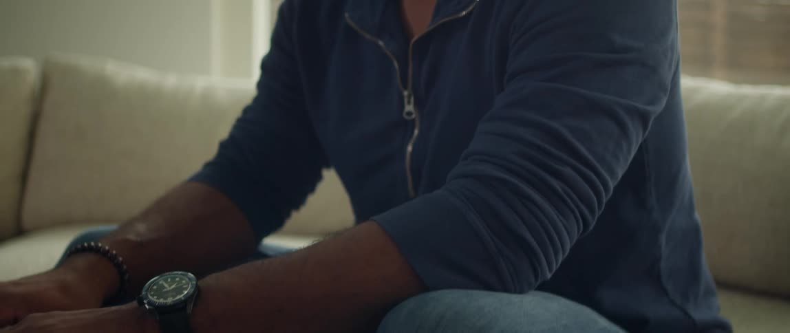 A man is using a laptop and cell phone