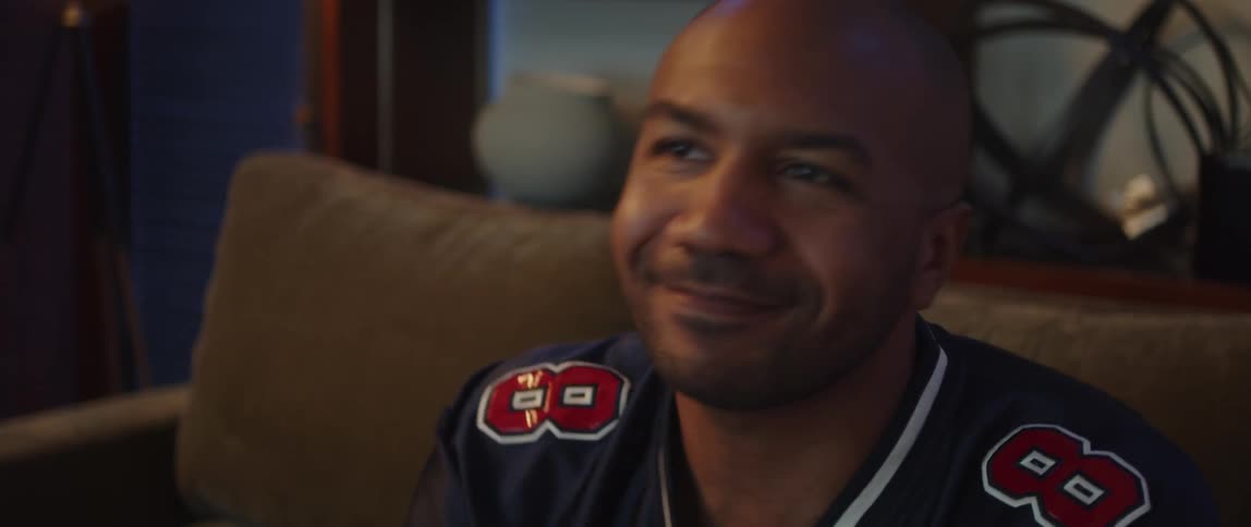 A man cheers but gets upset while watching sports at home