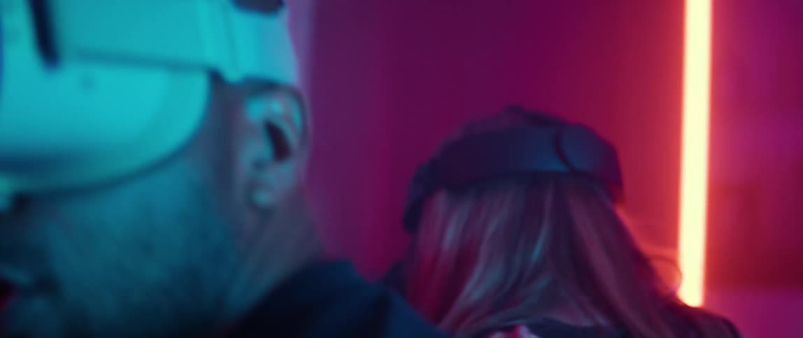 Couple of friends wearing virtual reality goggles playing a video game in a futuristic room