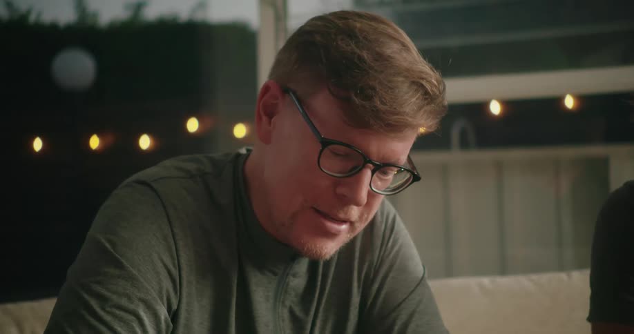 Two men are talking on a couch together