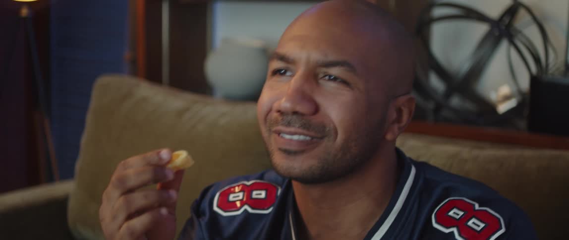 A man throws his snack down while watching something