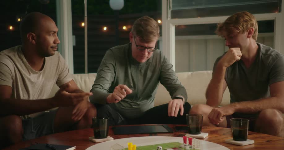 Three men are playing a board game together