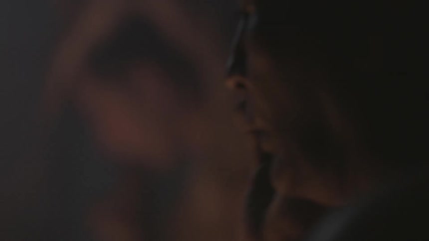 A man is talking and tapping a drum at night