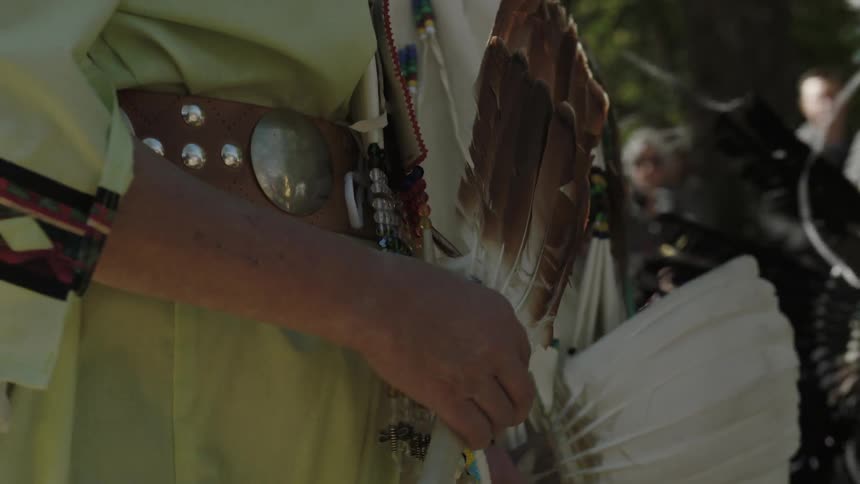 People holding fans of feathers