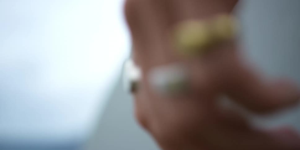 A man wearing multiple rings on his left hand