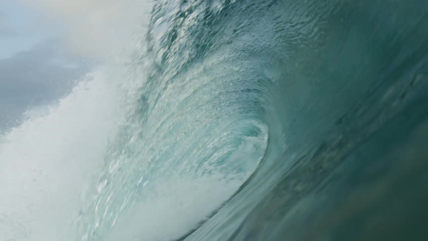 A large wave crashes into the sea